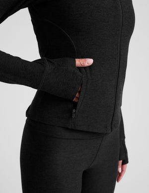 black zip-up mock neck jacket with pockets and thumbholes.